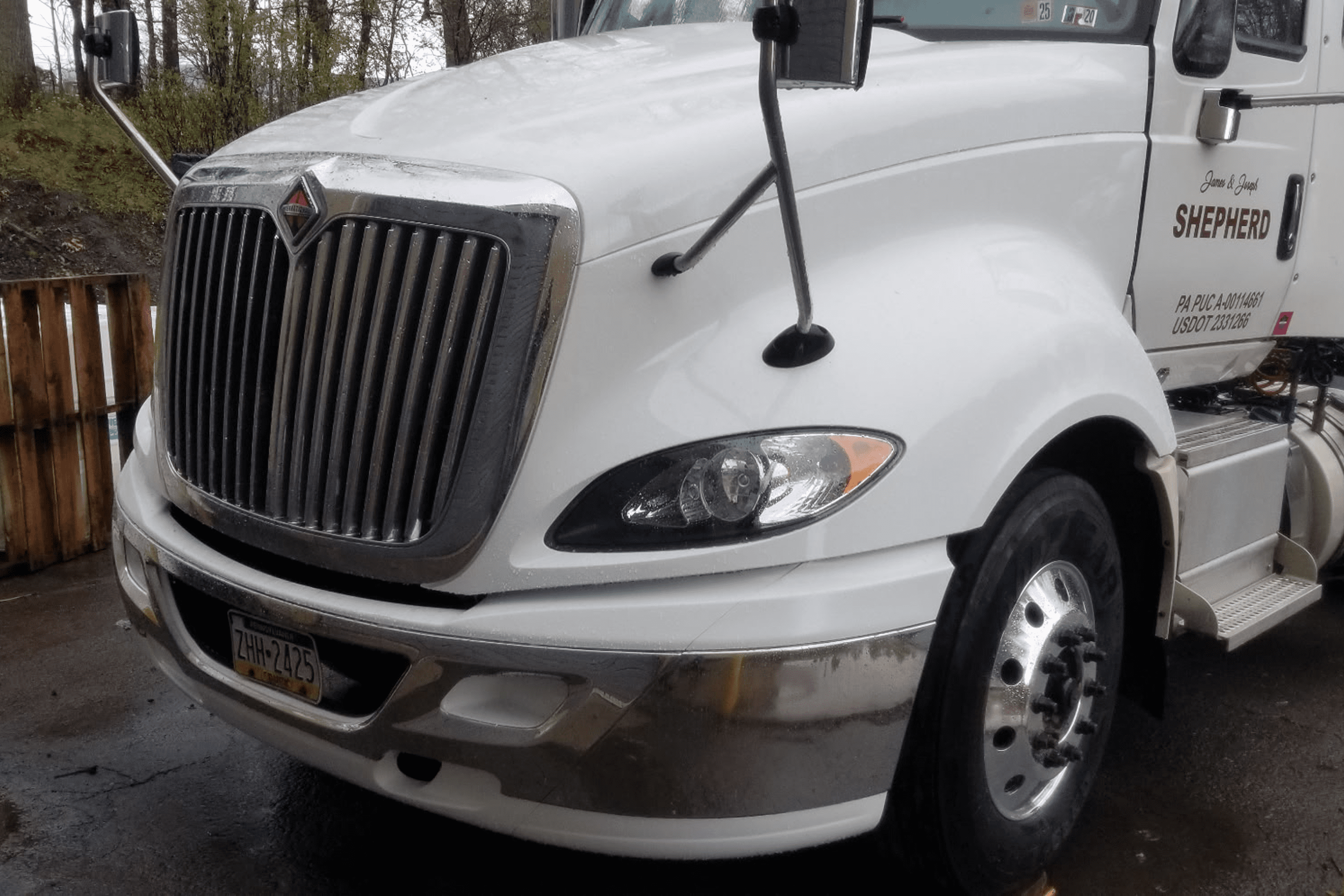 White freight truck parked on wet pavement.