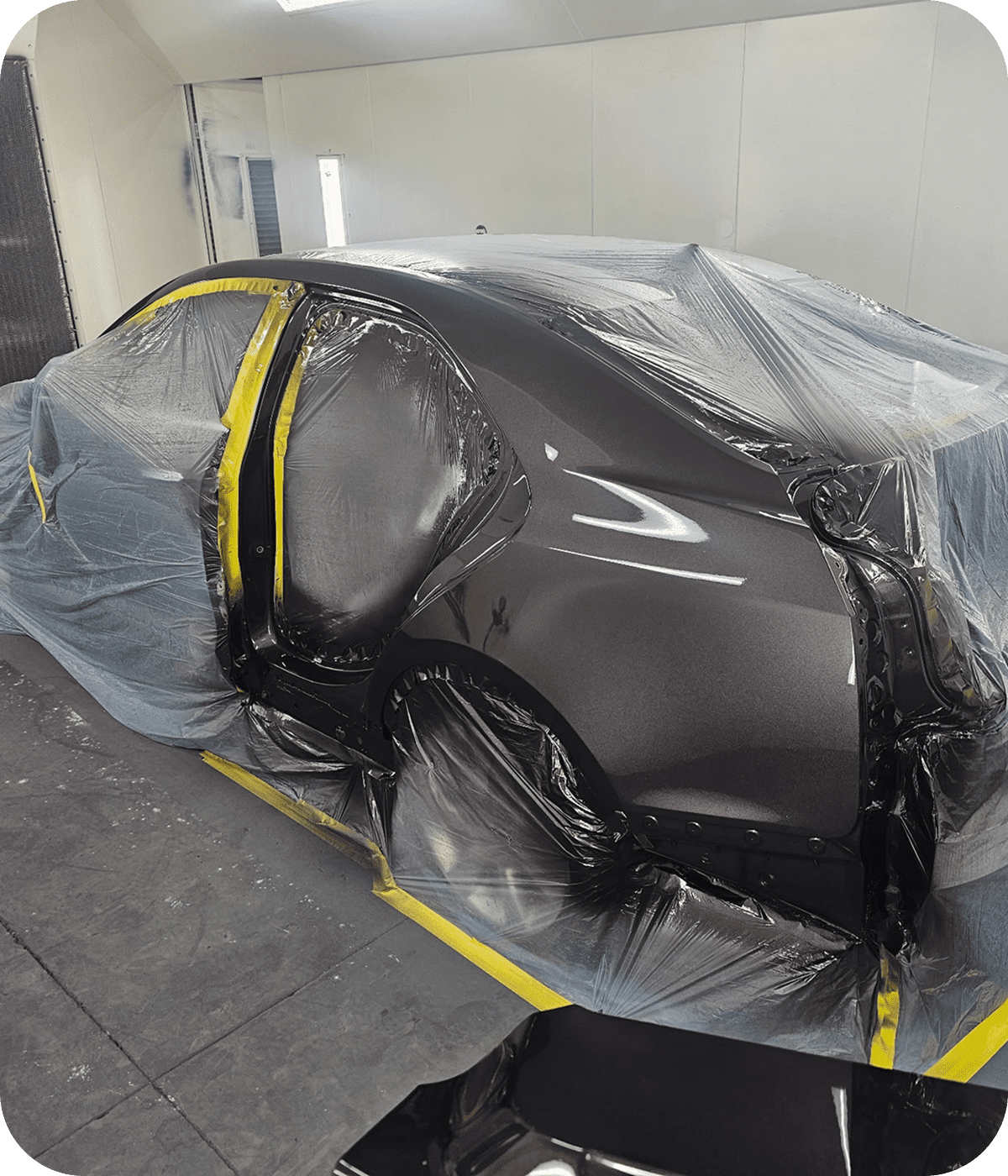 Automobile in paint booth with protective wrap